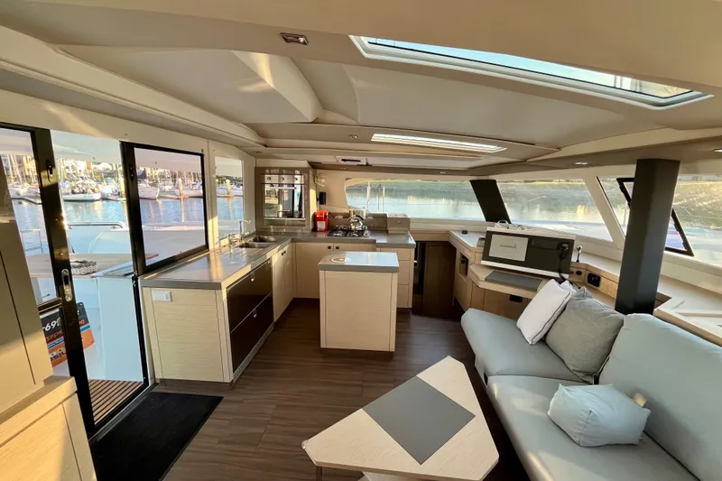 Bright Side Yacht Photos Pics Luxurious interior of 2018 Fountaine Pajot Saona catamaran with modern kitchen and seating area.
