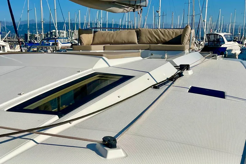 Bright Side Yacht Photos Pics 2018 Fountaine Pajot Saona catamaran deck with seating, docked in marina.