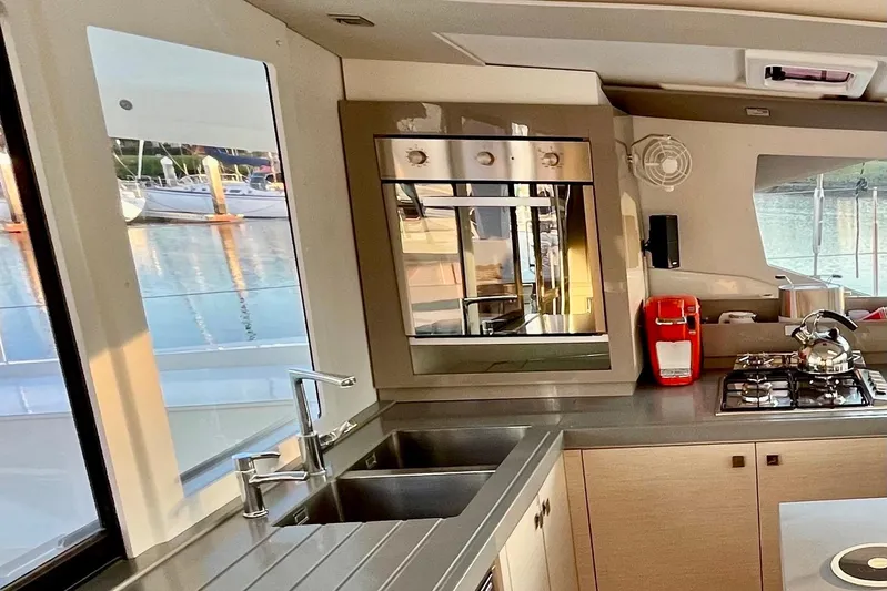 Bright Side Yacht Photos Pics Modern kitchen interior of 2018 Fountaine Pajot Saona catamaran with appliances and scenic window view.