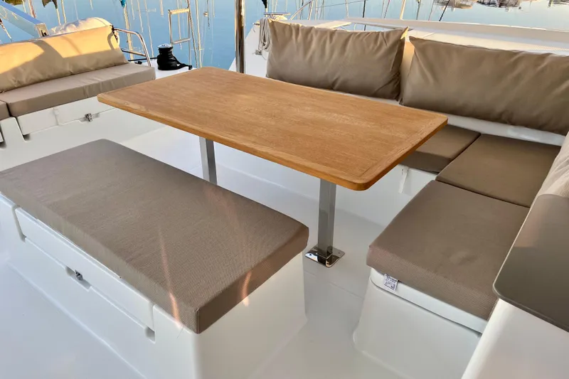 Bright Side Yacht Photos Pics 2018 Fountaine Pajot Saona yacht with elegant outdoor seating and wooden table.