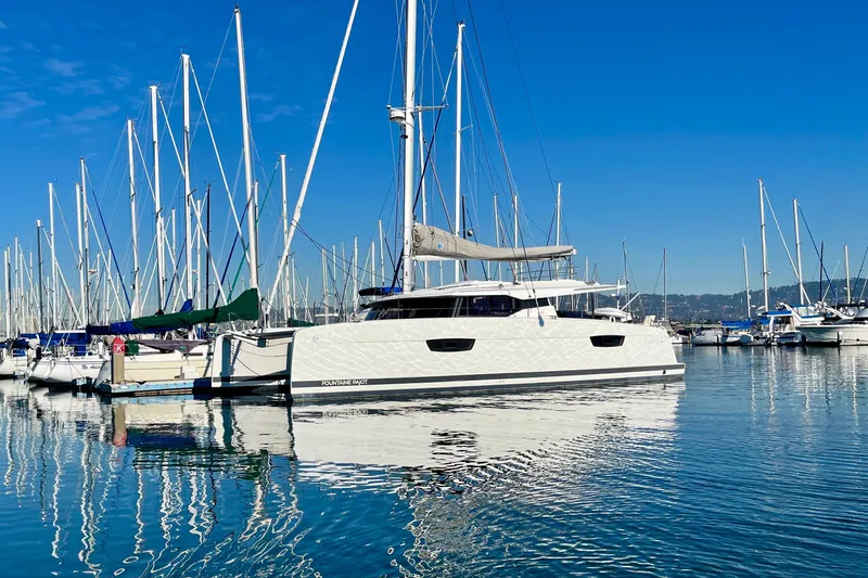 Bright Side Yacht Photos Pics 2018 Fountaine Pajot Saona catamaran docked in a marina under clear blue skies.