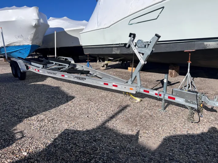  Yacht Photos Pics Boat trailer beside covered boats, gravel lot; 2022 Boston Whaler 280 Outrage.