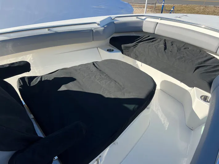  Yacht Photos Pics 2022 Boston Whaler 280 Outrage boat interior with cushioned seating and black covers.