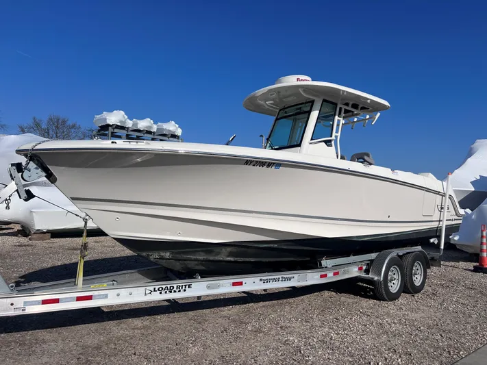  Yacht Photos Pics 2022 Boston Whaler 280 Outrage boat on trailer, side view, clear sky background.