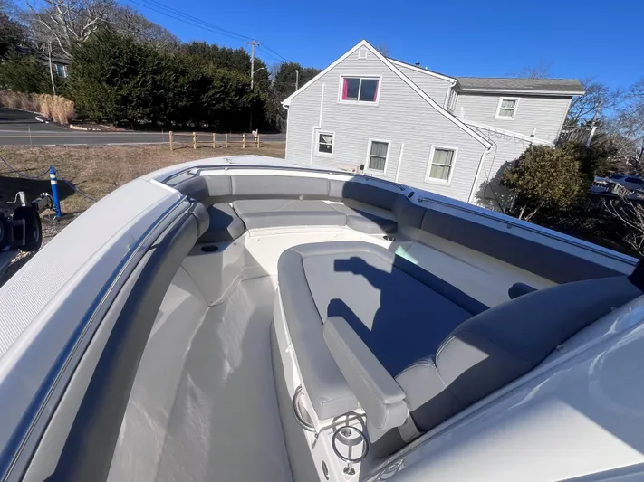  Yacht Photos Pics 2022 Boston Whaler 280 Outrage boat with spacious seating, docked near a residential area.