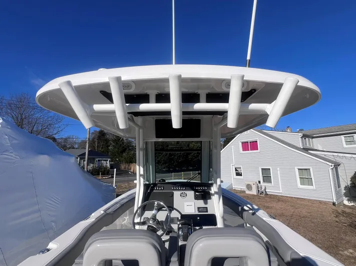  Yacht Photos Pics 2022 Boston Whaler 280 Outrage boat interior with helm and seating, under clear blue sky.