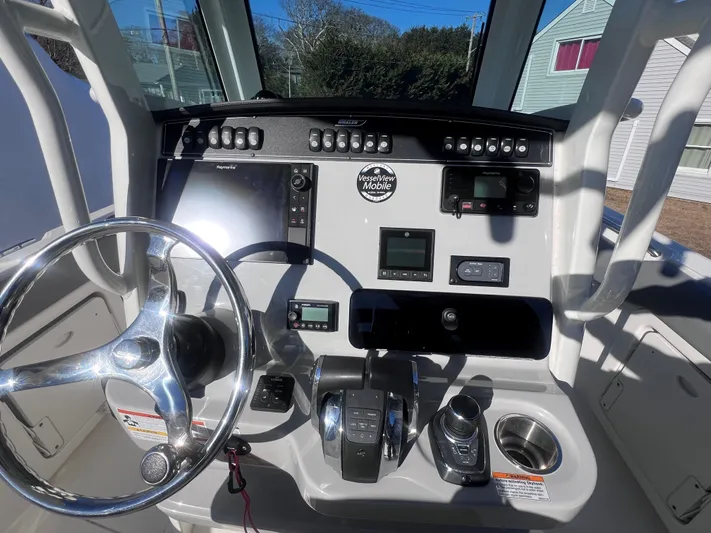  Yacht Photos Pics Boston Whaler 280 Outrage 2022 helm with steering wheel and navigation controls.