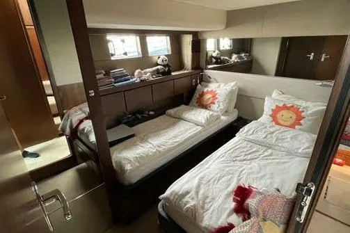  Yacht Photos Pics 2015 Fairline Squadron 67 yacht cabin with twin beds and sun-themed pillows.