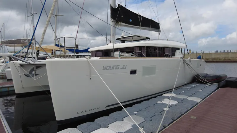  Yacht Photos Pics 2019 Lagoon 450S catamaran docked at marina under cloudy sky.