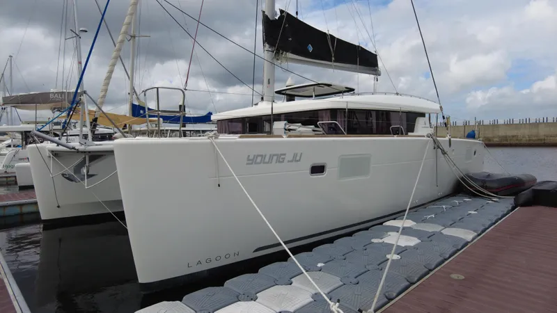  Yacht Photos Pics 2019 Lagoon 450S catamaran docked at marina under cloudy sky.