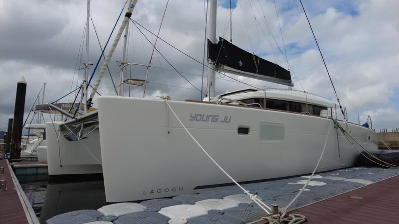  Yacht Photos Pics 2019 Lagoon 450S catamaran docked at marina under cloudy sky.