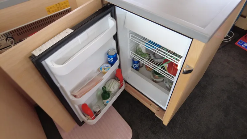  Yacht Photos Pics Open mini fridge in Lagoon 450S yacht, stocked with drinks and food items.