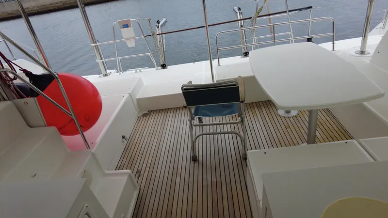  Yacht Photos Pics 2019 Lagoon 450S yacht deck with table, chair, and red buoy.
