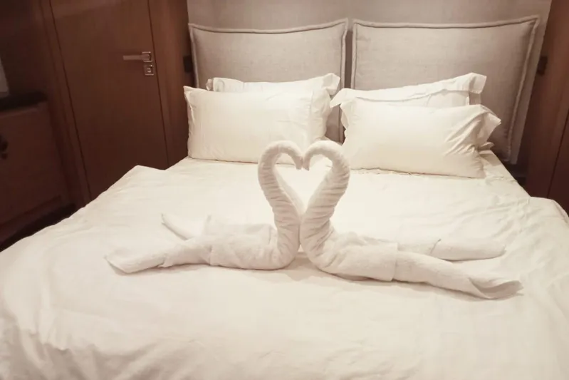  Yacht Photos Pics Luxurious Beneteau MC52 2022 cabin with elegant swan towel art on a plush bed.