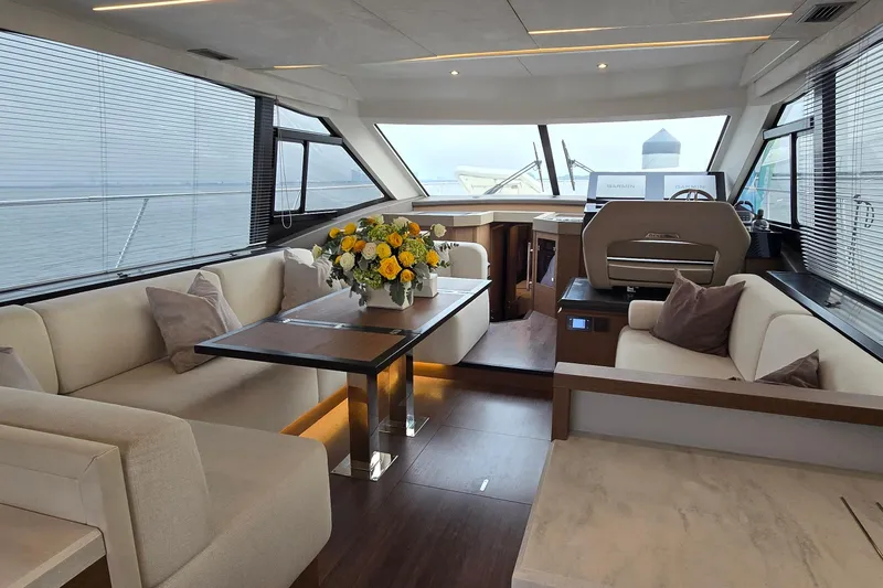  Yacht Photos Pics Luxurious interior of 2022 Monte Carlo MC52 yacht with elegant seating and floral centerpiece.