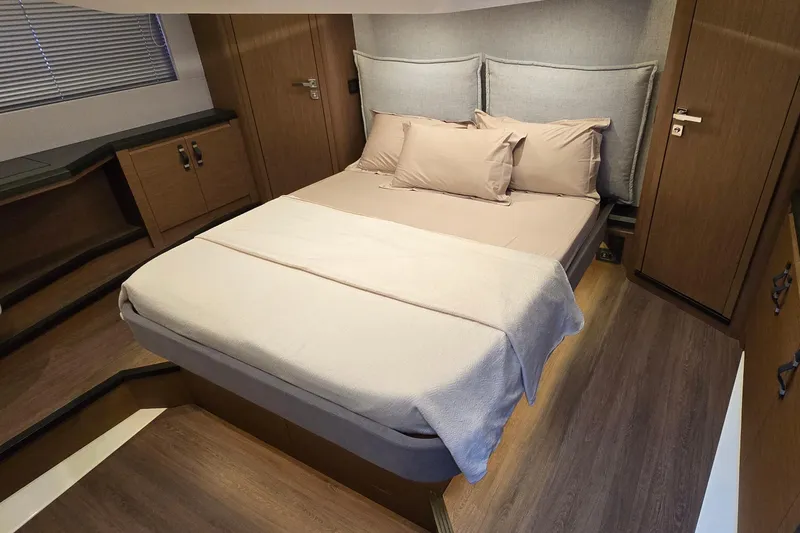  Yacht Photos Pics Luxurious bedroom interior of 2022 Monte Carlo MC52 yacht with modern wood finishes.