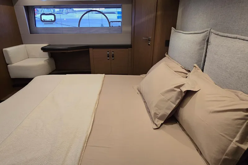  Yacht Photos Pics Luxurious bedroom interior of 2022 Monte Carlo MC52 yacht with elegant bedding and seating.