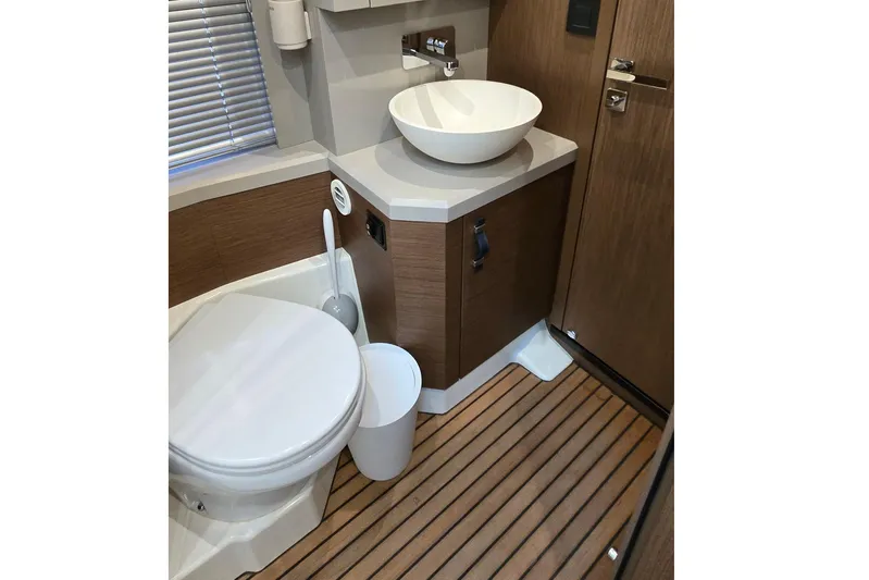  Yacht Photos Pics Modern bathroom in 2022 Monte Carlo MC52 yacht with wooden flooring and sleek fixtures.
