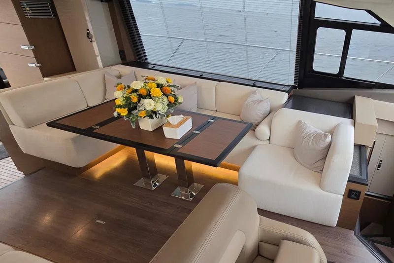  Yacht Photos Pics Luxurious interior of 2022 Monte Carlo MC52 yacht with elegant seating and floral centerpiece.