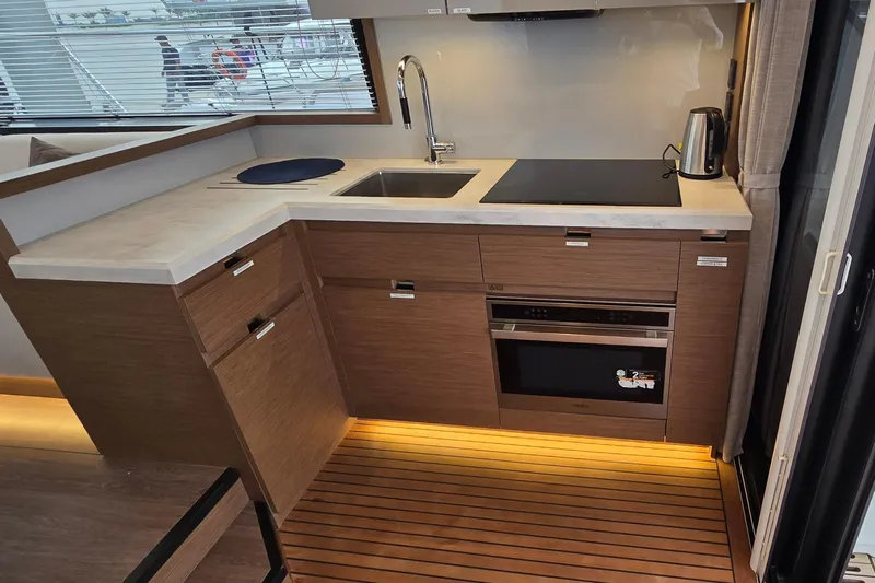  Yacht Photos Pics Modern kitchen in 2022 Monte Carlo MC52 yacht with sleek wood cabinetry and appliances.