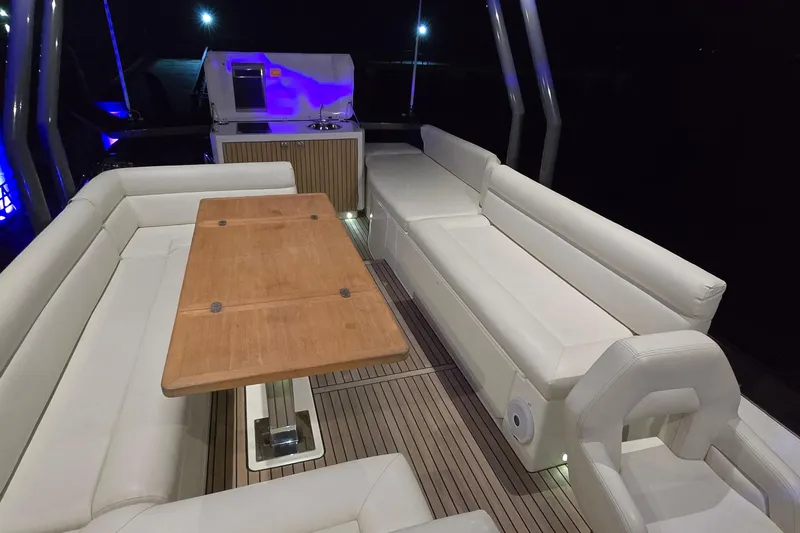  Yacht Photos Pics Luxurious 2022 Monte Carlo MC52 yacht interior with elegant seating and wooden table.