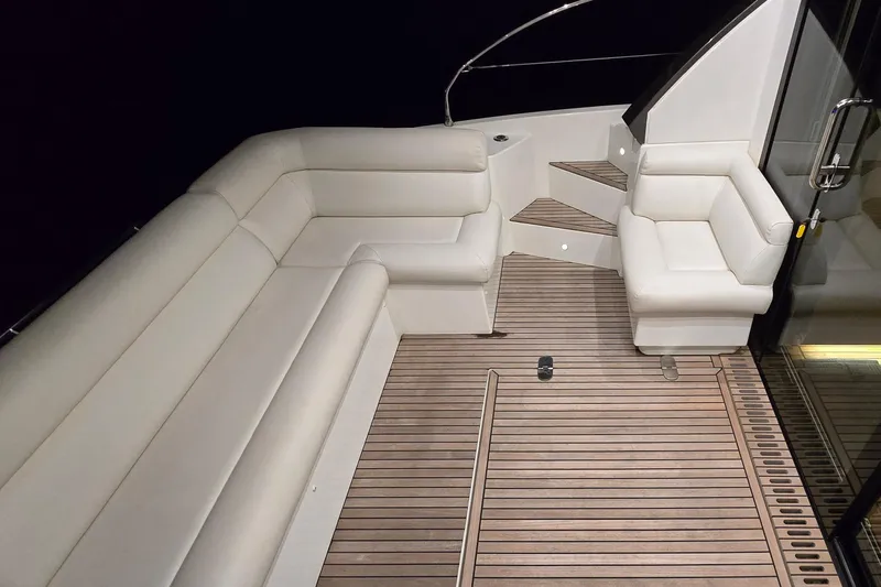  Yacht Photos Pics Luxurious 2022 Monte Carlo MC52 yacht interior with elegant seating and wooden flooring.