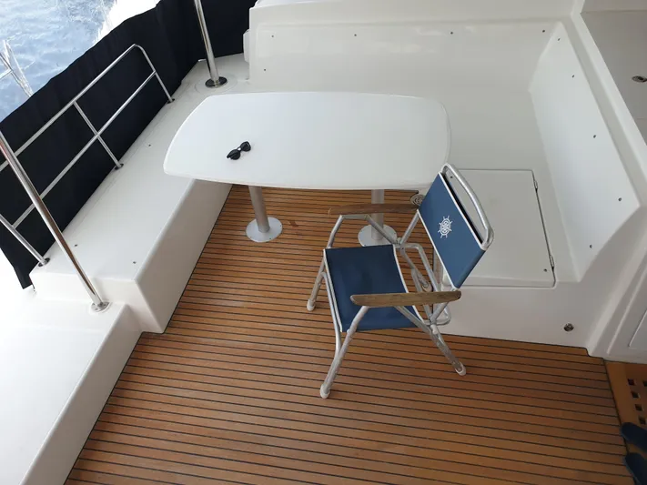  Yacht Photos Pics 2019 Lagoon 450S yacht deck with table, chair, and sunglasses.
