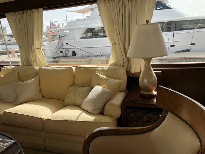 Dovetail Yacht Photos Pics Interior of a 1972 Trumpy 72 Houseboat with a cozy sofa and lamp.