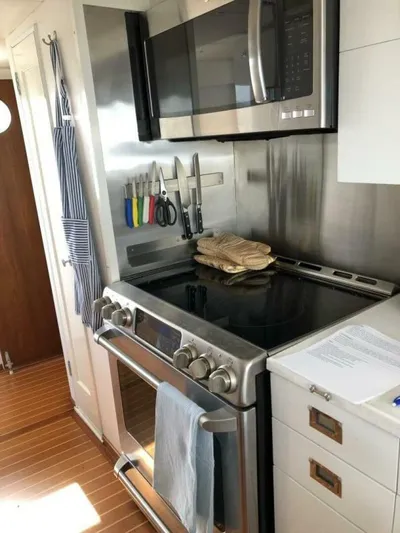 Dovetail Yacht Photos Pics Modern kitchen in a 1972 Trumpy 72 Houseboat with stainless steel appliances.