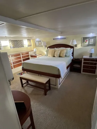 Dovetail Yacht Photos Pics Luxurious bedroom interior of a 1972 Trumpy 72 Houseboat with a cozy bed and ample storage.