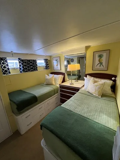 Dovetail Yacht Photos Pics Cozy bedroom in a 1972 Trumpy 72 Houseboat with twin beds and nautical decor.