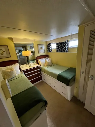 Dovetail Yacht Photos Pics Cozy bedroom in a 1972 Trumpy 72 Houseboat with twin beds and modern decor.