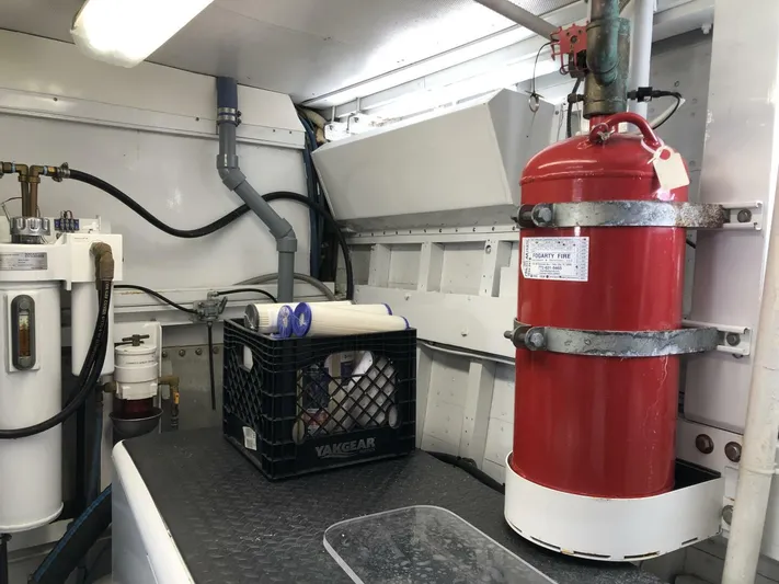 Dovetail Yacht Photos Pics Engine room of a 1972 Trumpy 72 Houseboat with fire extinguisher and maintenance equipment.