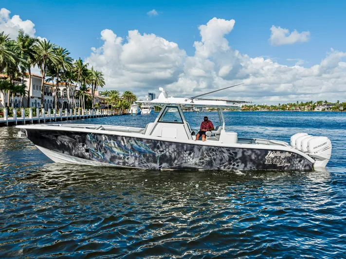  Yacht Photos Pics 2021 Yellowfin 39 boat cruising on a sunny day near palm-lined waterfront.
