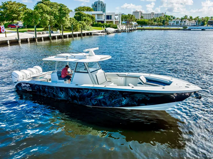  Yacht Photos Pics 2021 Yellowfin 39 boat cruising on a sunny waterfront with lush greenery.