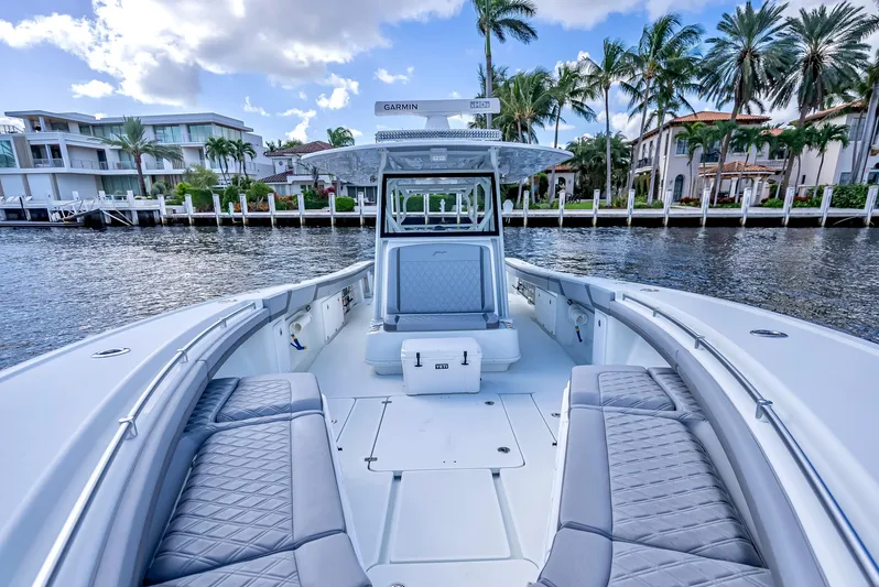  Yacht Photos Pics 2021 Yellowfin 39 boat with luxurious seating, docked by waterfront homes.