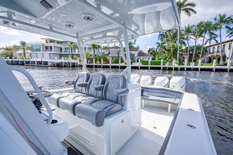  Yacht Photos Pics 2021 Yellowfin 39 boat with luxurious seating, docked near waterfront homes.