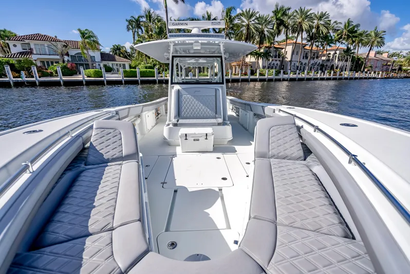  Yacht Photos Pics 2021 Yellowfin 39 boat with luxurious seating, docked by palm trees and waterfront homes.