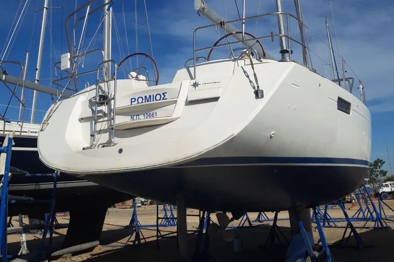  Yacht Photos Pics 2011 Jeanneau 53 sailboat on stands, viewed from the stern, under clear blue sky.