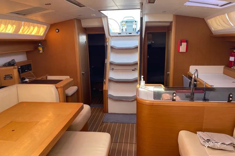  Yacht Photos Pics Interior of a 2011 Jeanneau 53 yacht featuring a cozy dining area and modern kitchen.