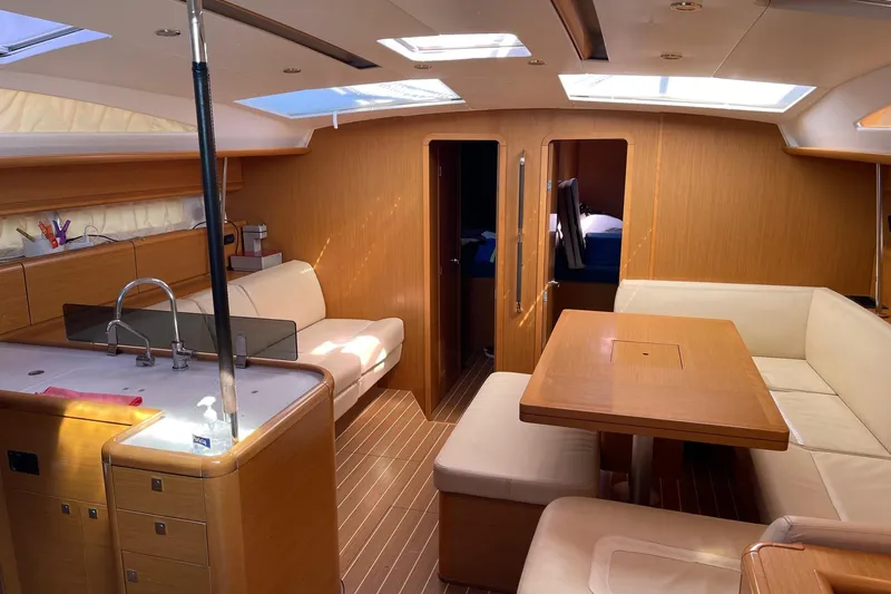 Yacht Photos Pics Luxurious interior of a 2011 Jeanneau 53 yacht with elegant wood finishes and seating.