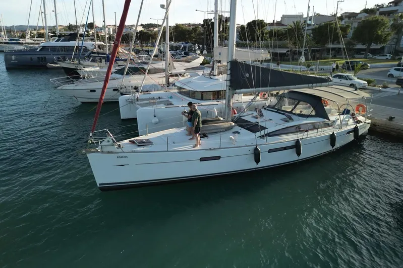  Yacht Photos Pics 2011 Jeanneau 53 sailboat docked at marina, with people on deck, surrounded by other boats.