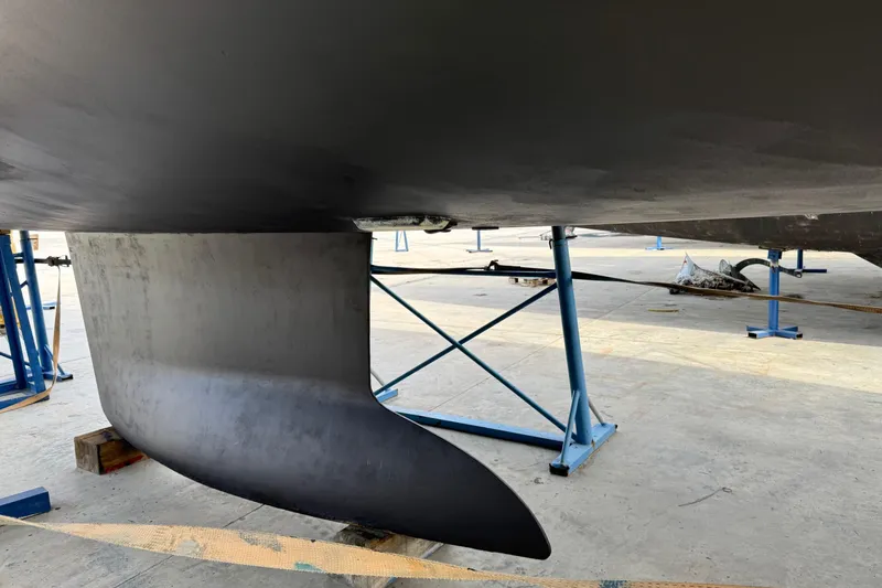  Yacht Photos Pics Keel of a 2011 Jeanneau 53 sailboat on a stand in a shipyard.