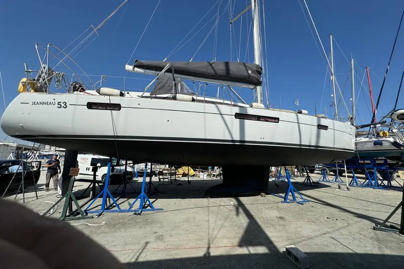  Yacht Photos Pics 2011 Jeanneau 53 sailboat on stands in a boatyard under clear blue sky.