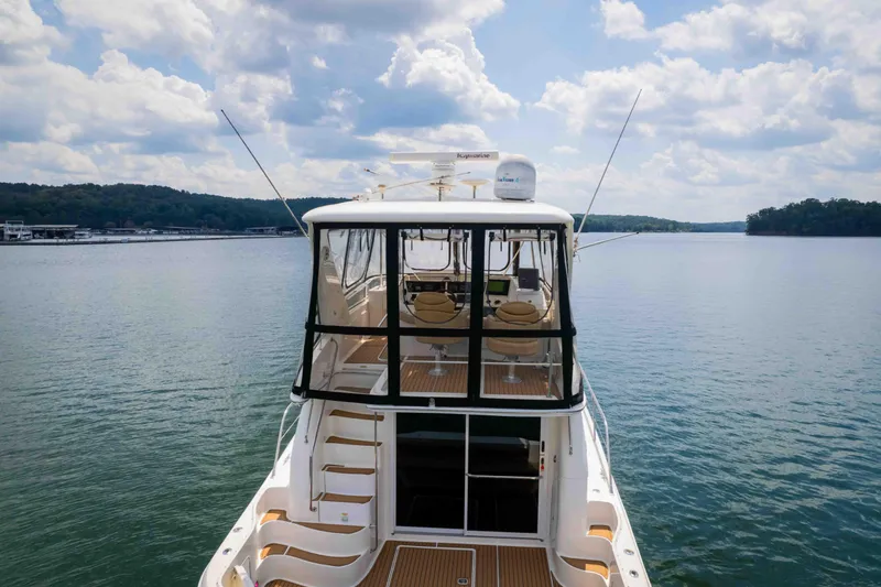  Yacht Photos Pics 1999 Sea Ray 480 Sedan Bridge yacht on calm water under a cloudy sky.