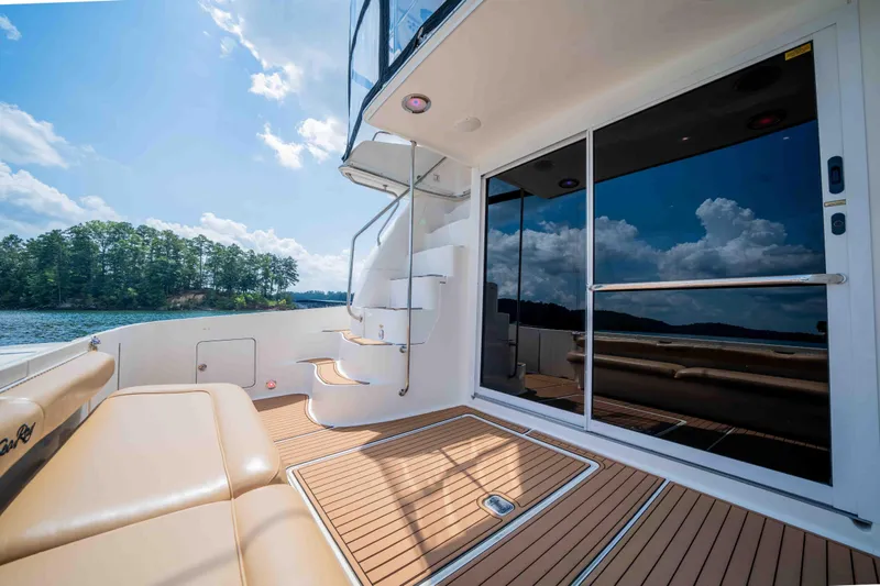  Yacht Photos Pics 1999 Sea Ray 480 Sedan Bridge yacht deck with seating, stairs, and scenic lake view.