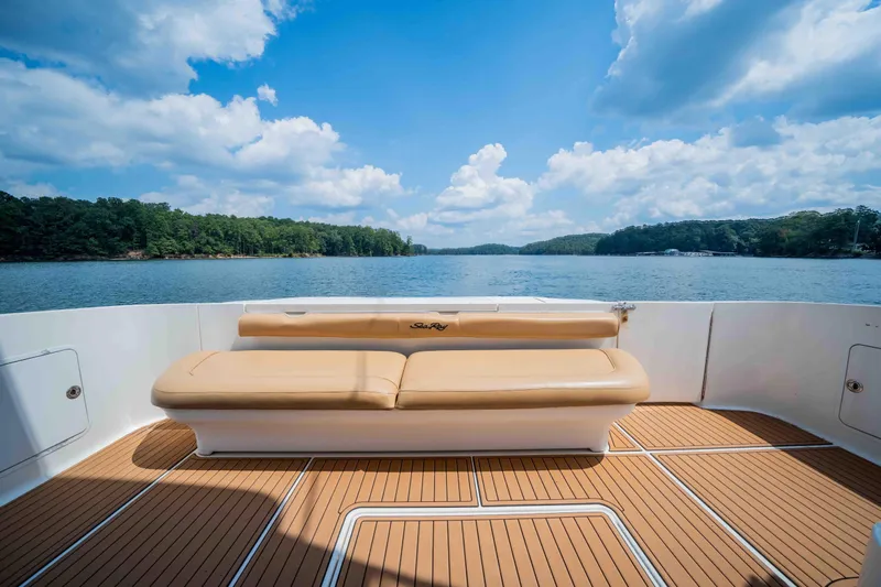  Yacht Photos Pics 1999 Sea Ray 480 Sedan Bridge yacht deck with seating, overlooking serene lake and forest.