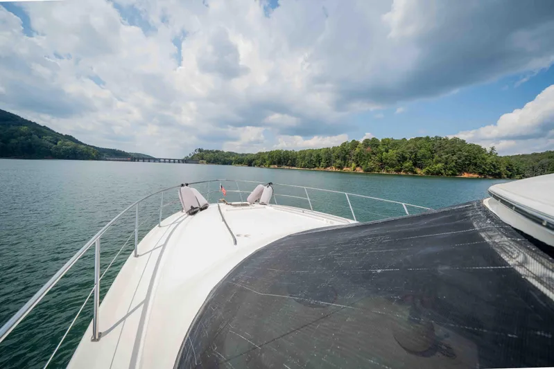  Yacht Photos Pics 1999 Sea Ray 480 Sedan Bridge cruising on a scenic lake with lush green shoreline.