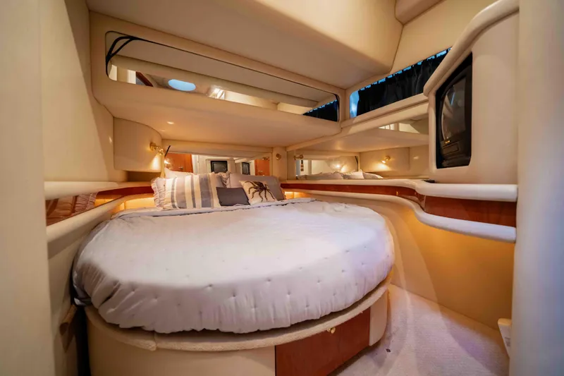  Yacht Photos Pics Luxurious bedroom interior of 1999 Sea Ray 480 Sedan Bridge yacht, featuring cozy round bed.