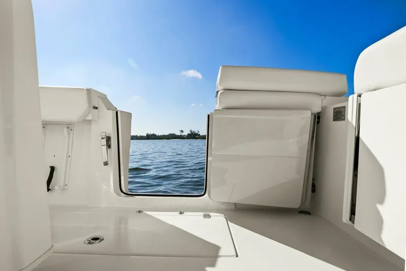  Yacht Photos Pics 2023 Cobia 301 Center Console boat interior with open door, overlooking serene water and blue sky.